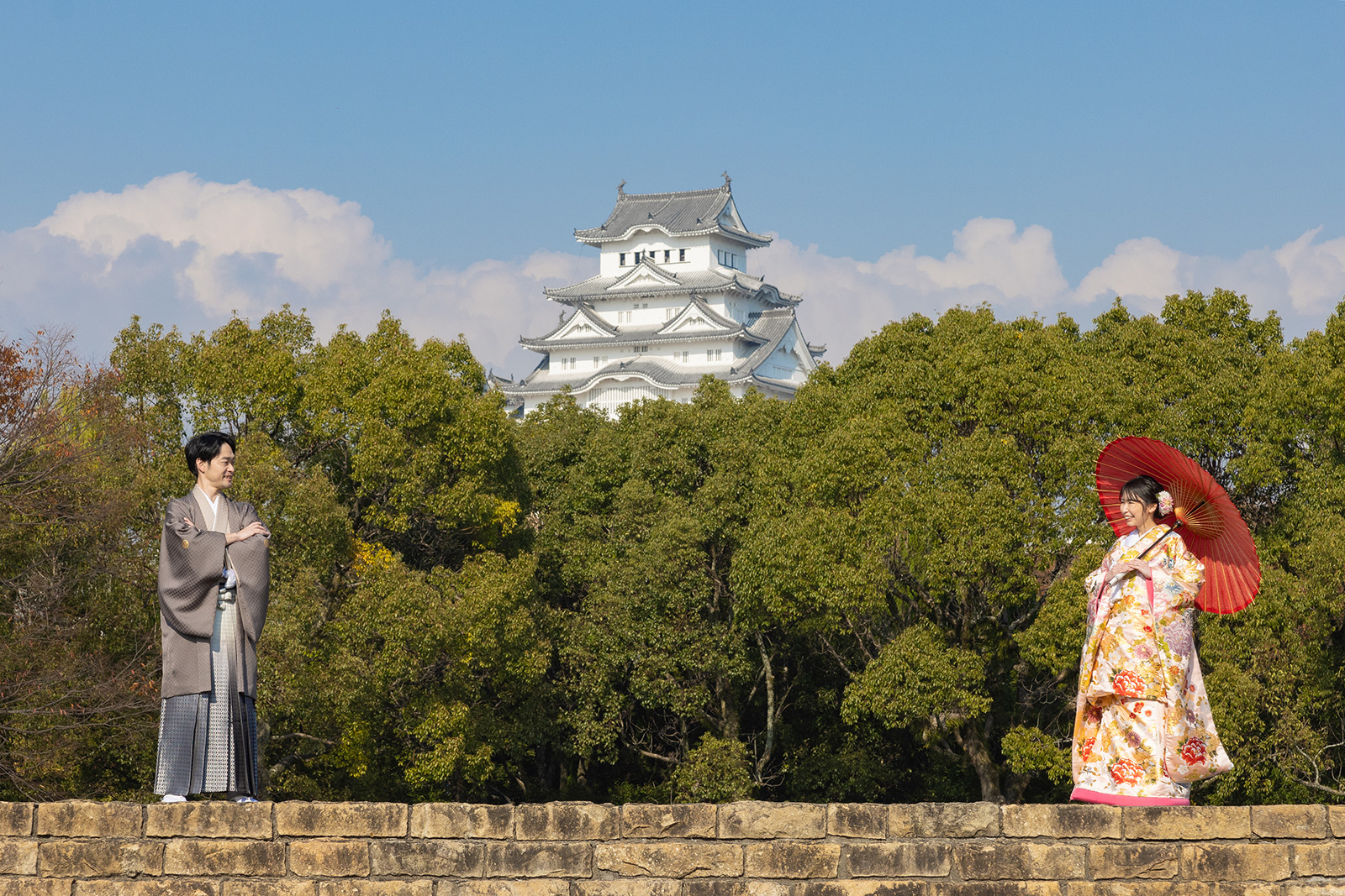 姫路城を背景にした和装フォトウェディング。豪華な色打掛を着た新婦と紋付袴の新郎のロケーション撮影。